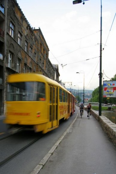 Miljacka nehri kıyısında tramvay ve bisikletle gezen Saraybosnalılar.