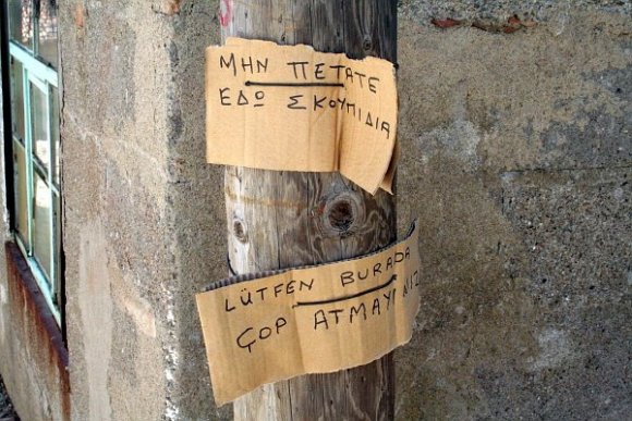 Gökçeada Zeytinliköy'de Rumca ve Türkçe yazılmış uyarı.