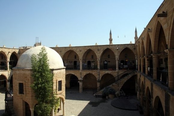 Lefkoşe'deki Büyük Han ve arkada Kıbrıs ve Türk bayraklarının yan yana dalgalandığı Selimiye Camii.