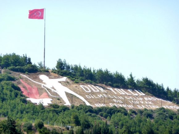 Kilitbahir sırtlarındaki "Dur Yolcu" yazısı ve bayrak.