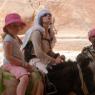 Petra içinde eşeklerle gezen anne-kız turistler.