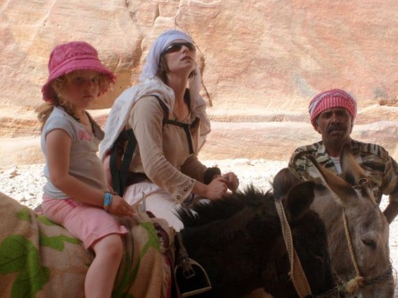 Petra içinde eşeklerle gezen anne-kız turistler.