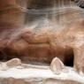 Petra - Siq boyunca kayaya oyulmus deve ve önünde bir adam heykeli.
